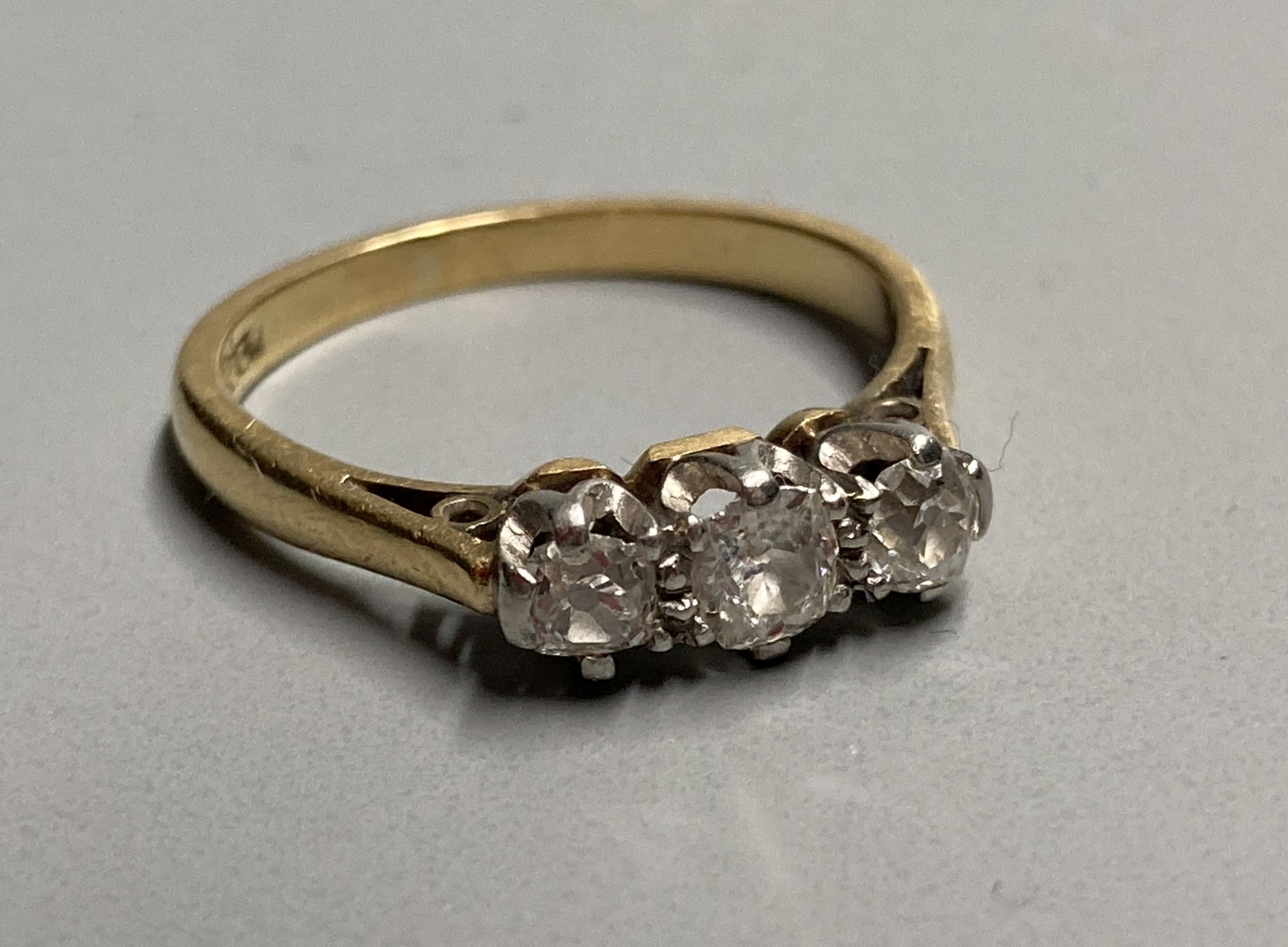 A mid 20th century 18ct and three stone diamond ring, size K/L, gross 2.7 grams.